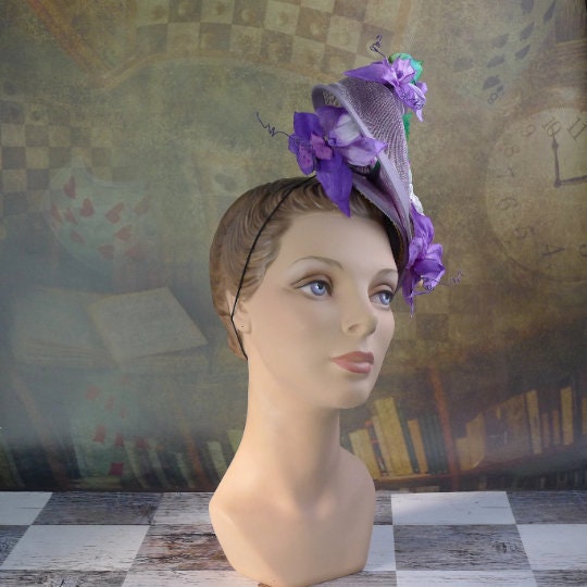 Amethyst Twist hat in shimmering lavendar sinamay headpiece with handmade orchids and hibiscus flowers, handsewn silk bias brim.  In Stock